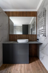 New bathroom with installed furniture and sink with a huge mirror in a modern style