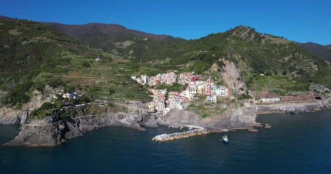 World famous sightseeing spot of Cinque Terre, Italy. Manarola, small town on rocky cliff, sunny day - aerial drone