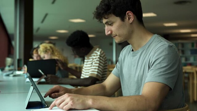 Young multiracial students learing together inside school library