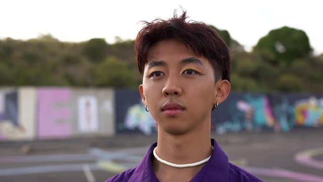 Young asian man with make up looking on camera
