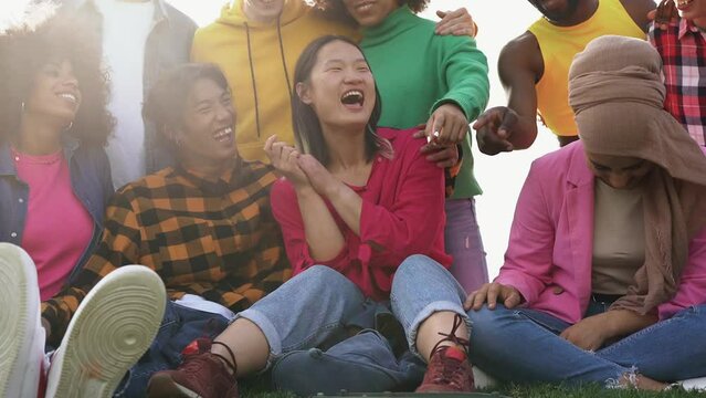 Happy diverse people having fun together at city park - Multiracial friends enjoy day outdoor	