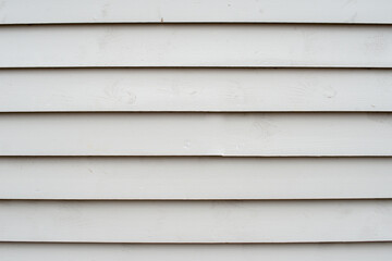 The exterior wall of a white exterior building. The textured wood is made of pine clapboard and the...
