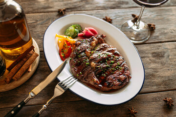 Portion of grilled beef steak with red wine on wooden background