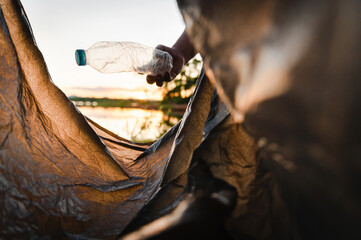 hand picking up garbage plastic bottle for cleaning at park