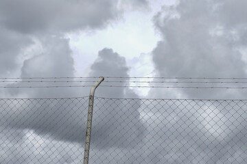 Grey metallic net against dark sky. Conceptual for crisis, security, border, conflict