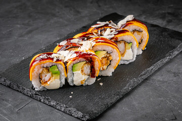 delicious sushi rolls on a black stone background