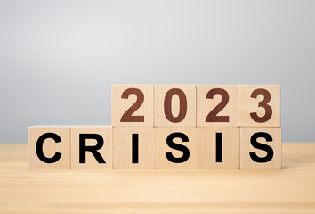 Crisis management concept in new year 2023 . Wooden cubes 2023 with text crisis. Bankruptcy and...