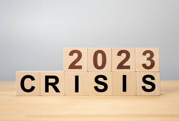 Crisis management concept in new year 2023 . Wooden cubes 2023 with text crisis. Bankruptcy and financial crisis concept.
