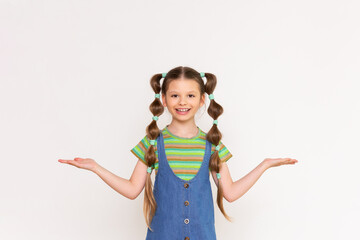 The child holds the advertisement on both sides on a white isolated background. A beautiful little girl in a denim sundress.