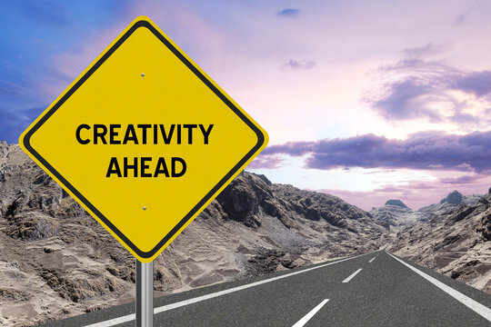Yellow highway sign with the word Creativity and a metaphoric road leading to future success.