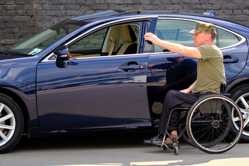 man with disability uses a wheelchair to move around the car, driver with disability