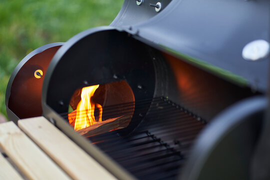 New smoker barbecue grill. Light it properly. Blazing flames. Closeup.