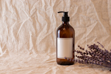 Empty amber glass soap or shampoo bottle on isolated background. Skin care or hair concept with...