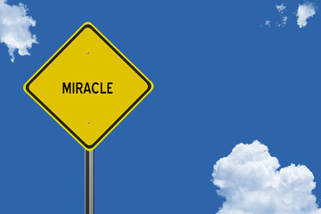 The word Miracle on a yellow road sign on a blue sky background.  Inspirational concept for success in life.