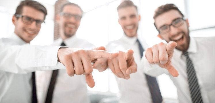 background image of a successful business team pointing to you