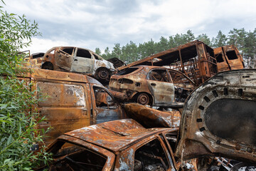Fototapeta na wymiar War in Ukraine. Car graveyard in Irpin. Shot cars of civilians.
