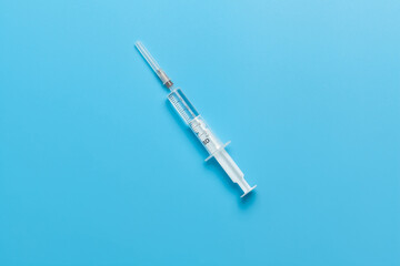 Medical syringe for liquid 5 ml. White medical syringe isolated on a blue background.