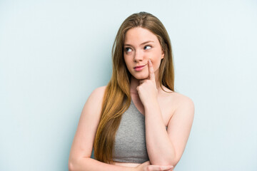 Young caucasian woman isolated on blue background contemplating, planning a strategy, thinking about the way of a business.