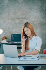 Portrait of smiling pretty young business woman sitting on workplace