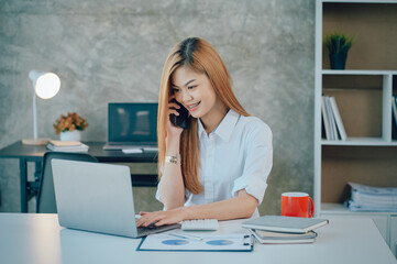 Portrait of smiling pretty young business woman sitting on workplace