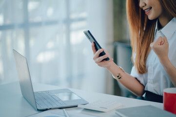 Portrait of smiling pretty young business woman sitting on workplace
