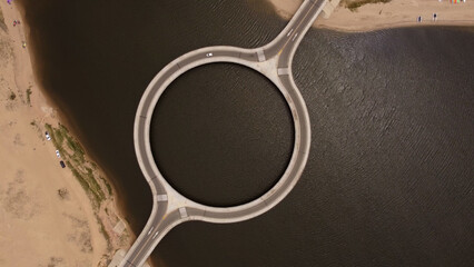 Aerial top down shot of empty Laguna Garzon Circular Bridge in Uruguay during sunlight