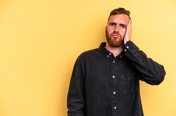 Obraz premium Young caucasian man isolated on yellow background who feels sad and pensive, looking at copy space.