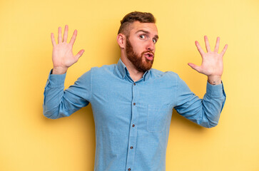 Fototapeta na wymiar Young caucasian man isolated on yellow background being shocked due to an imminent danger
