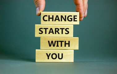 Change starts with you symbol. Concept words Change starts with you on wooden blocks on a beautiful grey table grey background. Businessman hand. Business motivational change starts with you concept.