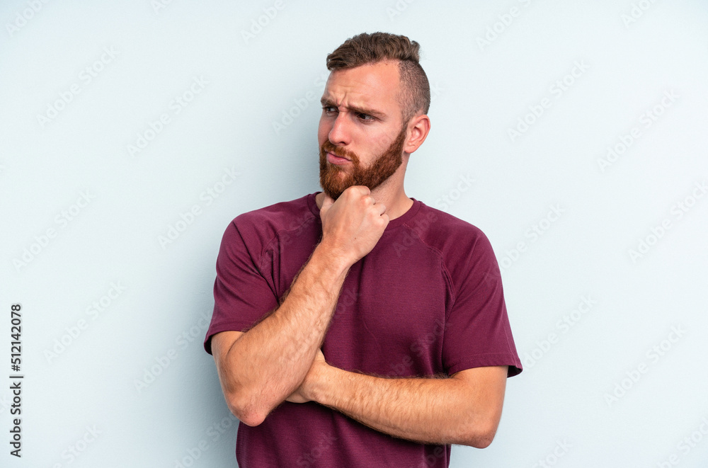 Wall mural Young caucasian man isolated on blue background suffers pain in throat due a virus or infection.