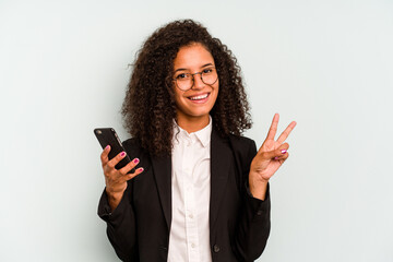 Young business Brazilian woman holding mobile phone isolated on white background joyful and...