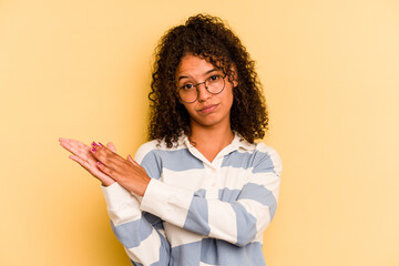 Young Brazilian woman isolated on yellow background feeling energetic and comfortable, rubbing hands confident.