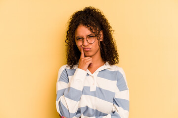 Young Brazilian woman isolated on yellow background unhappy looking in camera with sarcastic...