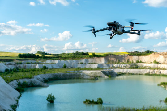 Grodno, Belarus June 11, 2022: A drone DJI MAVIC 3 explores an old abandoned quarry. Aerial photography of an industrial facility. An engineer uses a quadcopter to search for minerals.