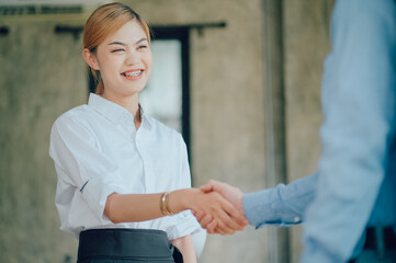 Portrait of smiling pretty young business woman sitting on workplace