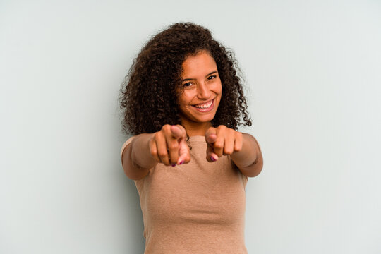 Young Brazilian woman isolated on blue background pointing to front with fingers.