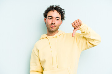 Young caucasian man isolated on blue background showing thumb down, disappointment concept.