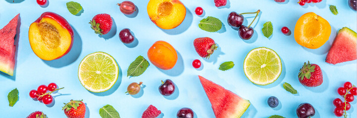 Summer vitamin food concept, various fruit and berries watermelon peach mint plum apricots blueberry strawberry currant, creative flat lay on light blue background top view copy space