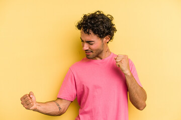 Young caucasian man isolated on yellow background dancing and having fun.