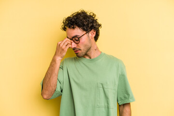 Young caucasian man isolated on yellow background having a head ache, touching front of the face.