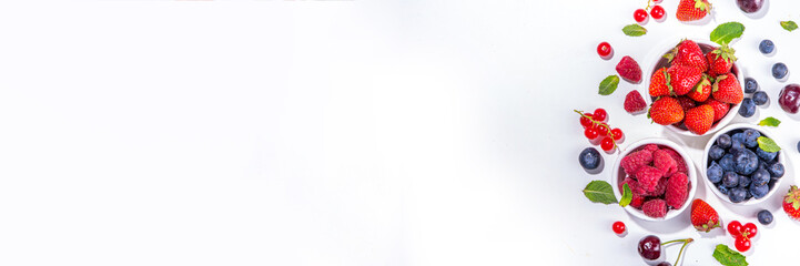 Summer vitamin food concept, set of various berries blueberry strawberry currant, flat lay on white background top view copy space