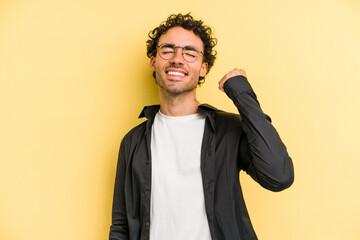 Young caucasian man isolated on yellow background celebrating a victory, passion and enthusiasm, happy expression.
