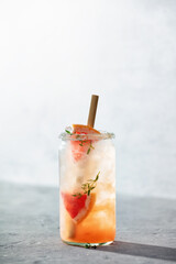 Trendy summer drink with grapefruit and rosemary close up. Sunny day shadows