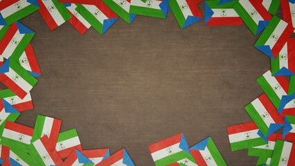 Fototapeta premium Frame made of paper flags of Equatorial Guinea arranged on wooden table. National celebration concept. 3D illustration