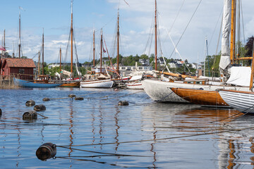 Wooden sailboats reflected on the water in Fredrikstad, Norway. - obrazy, fototapety, plakaty