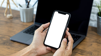 Hands of a businessman using a  smartphone mockup at his desk, Mobile phone blank screen for editing graphics.