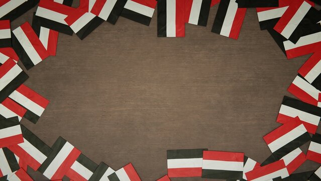 Frame made of paper flags of Yemen arranged on wooden table. National celebration concept. 3D illustration