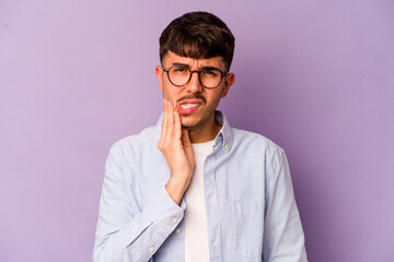 Young caucasian man isolated on purple background having a strong teeth pain, molar ache.
