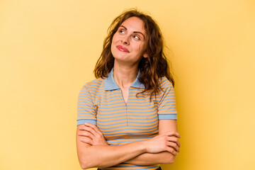 Obraz premium Young caucasian woman isolated on yellow background dreaming of achieving goals and purposes