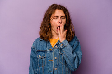 Young caucasian woman isolated on purple background yawning showing a tired gesture covering mouth with hand.